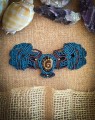 Ręcznie wykonana mucha męska z amonitem, mikromakrama na turkusowym sznurku Linhasita z dodatkami brązowego splotu, koraliki w kolorze miedzi, unikatowa biżuteria męska handmade Imvelo, część pierwszej w Polsce kolekcji much z kamieniami naturalnymi.
