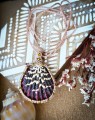 Unikatowy naszyjnik z naturalną muszlą wykonany metodą mikromakramy. Polska biżuteria handmade w stylu boho z pełną regulacją długości oraz złoconym hematytem.
